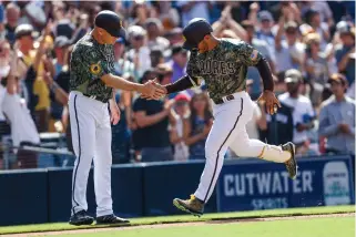  ?? MIKE MCGINNIS/ASSOCIATED PRESS ?? From right to left, San Diego’s Trent Grisham celebrates with third base coach Mike Shildt after hitting a two-run walk-off home run against the Pittsburgh Pirates during the 10th inning on Sunday.