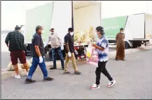  ?? Photo by Bassam Abu Shanab ?? Charity volunteers distributi­ng food parcels to residents of Hawally during
the lockdown period last week.