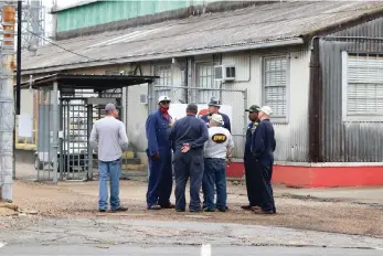  ?? (Courtesy of Penny Chanler) ?? Delek workers stand together after a fire that broke out at the refinery Saturday was under control.