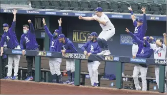  ?? TONY GUTIERREZ — THE ASSOCIATED PRESS ?? The Dodgers celebrate a home run by Justin Turner during the first inning in Game 6 of the National League Championsh­ip Series against the Braves on Saturday in Arlington, Texas.