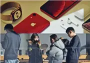  ?? (AFP) ?? Customers look at products in an Apple store in Beijing on Tuesday