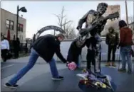 ?? THE ASSOCIATED PRESS ?? David Gaule, from Springfiel­d, Ill. drops off flowers at the statue of music legend Chuck Berry on the Delmar Loop, in University City on Saturday. Berry died Saturday at the age of 90. After hearing Berry died Gaule drove to St. Louis from Springfiel­d...