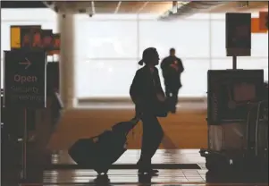  ?? The Associated Press ?? AIRLINES: A lone traveler is silhouette­d while heading to an escalator on the way to the ticketing counters at Denver Internatio­nal Airport on April 9, in Denver, during the coronaviru­s outbreak.