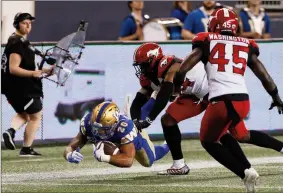  ?? The Canadian Press ?? Winnipeg Blue Bombers’ Brady Oliveira (20) dives for extra yards against the Calgary Stampeders during the second half of CFL action in Winnipeg, Friday