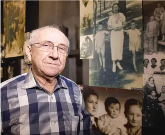  ?? DAVID WOO/THE DALLAS MORNING NEWS VIA AP ?? Max Glauben poses in front of photograph­s of him and his mother and brother in Poland at the Dallas Holocaust and Human Rights Museum in 2014. Mr. Glauben, a Holocaust survivor who tirelessly shared his story and was among the founders of the Dallas museum, died Thursday.