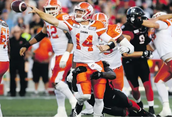  ?? JUSTIN TANG/THE CANADIAN PRESS ?? Lions pivot Travis Lulay throws the ball to avoid the tackle of Ottawa’s A.C. Leonard Friday night in Ottawa. The Lions lost 29-25 to fall to 2-3 this season.