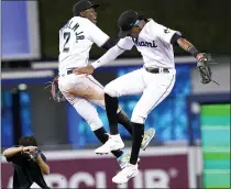  ?? LYNNE SLADKY — THE ASSOCIATED PRESS ?? Miami Marlins’ Jazz Chisholm Jr. (2) and Lewis Brinson, right, celebrate after a baseball game against the New York Mets, Thursday, Aug. 5, 2021, in Miami. The Marlins won 4-2.