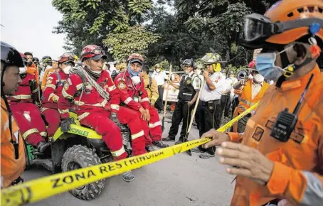  ?? BILDER: SN/AFP/AP ?? Die ersten Opfer wurden bereits beigesetzt. Indessen warten Feuerwehrl­eute auf den nächsten Einsatz.
