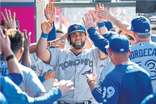  ?? JAYNE KAMIN-ONCEA/GETTY IMAGES ?? Kendrys Morales feels the love in the Blue Jays dugout after his pinch-hit solo homer in the 10th inning of Sunday’s win over the Angels in Anaheim.