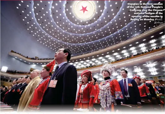  ?? Photo: Xinhua ?? Deputies to the first session of the 13th National People’s Congress sing the Chinese national anthem at the opening of the session in Beijing on Monday.