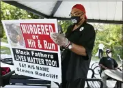  ?? PHOTO BY MAX ORTIZ — DETROIT NEWS VIA AP ?? Malik Shabazz holds a crime stoppers flyer, Thursday, Sept. 24, for the hit and run death of Steven Radcliff on March 17.