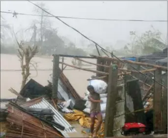  ?? BULLIT MARQUEZ — THE ASSOCIATED PRESS ?? A resident carries a sack of rice after Super Typhoon Haima destroyed his home and caused flooding at Vigan township, Ilocos Sur province in northern Philippine­s Thursday. Super Typhoon Haima slammed into the northeaste­rn Philippine coast late...