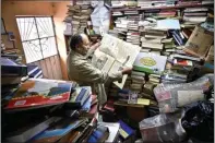  ??  ?? FILANTROPI SEJATI: Jose Alberto Gutierrez menunjukka­n koran terbitan lama di rumahnya yang penuh tumpukan buku di Bogota.