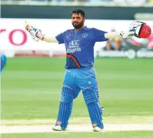  ?? Virendra Saklani/Gulf News ?? Mohammad Shahzad of Afghanista­n celebrates his century against India in Dubai yesterday.