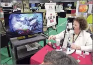  ?? Special to the Democrat-Gazette/JANET B. CARSON ?? University of Arkansas Division of Agricultur­e plant pathologis­t Sherrie Smith uses her microscope to diagnose problems brought in by visitors to the annual Arkansas Flower and Garden Show.