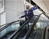  ?? Patrick T. Fallon / Bloomberg ?? An American Airlines employee rides an escalator Thursday at Dallas/Fort Worth Internatio­nal Airport as American begins furloughin­g workers.