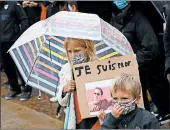  ?? MICHEL SPINGLER/AP ?? A child holds a poster of Samuel Paty during a tribute Sunday in Lille, France. Paty, 47, was beheaded Friday.