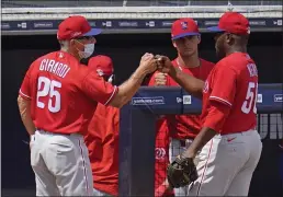  ?? GENE J. PUSKAR THE ASSOCIATED PRESS ?? Phillies manager Joe Girardi, left, gives reliever Hector Neris, right, a fist bump after a spring training game against the Yankees. Girardi said Neris will be the closer to start the season.