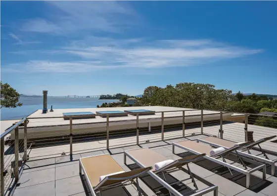  ?? OPENHOMESP­HOTOGRAPHY ?? Above: The roof deck of the San Rafael home offers sweeping views of the water and the Richmond-San Rafael Bridge. Below left: Views of the bay are visible in many rooms of the San Rafael home. Below right: The primary suite’s spa bathroom boasts a walk-in shower and a soaking tub perched beneath a picture window.