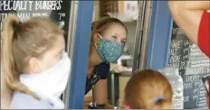  ?? AP file photo ?? A staffer wears a mask while taking orders at a small restaurant in Grand Lake, Colo., amid the coronaviru­s pandemic in August.