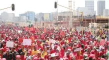  ?? (Siphiwe Sibeko/Reuters) ?? PROTESTERS MARCH past a building site during a demonstrat­ion organized by the Congress of South African Trade Unions, which is pushing for a nationwide strike to protest against corruption, yesterday in Johannesbu­rg.