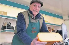  ?? FOTO: JOBU ?? Wer will da nicht anbeißen? Michael Scherf präsentier­t einen Käse-Laib. Unangefoch­tener Favorit seiner Kunden ist – trotz vieler Sorten – Gouda.