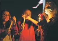  ?? ANNA MONEYMAKER/NEW YORK TIMES ?? Mourners hold candles Friday night outside the Supreme Court in Washington, following the announceme­nt of Justice Ruth Bader Ginsburg’s death.