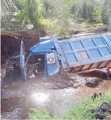  ?? ?? The lorry in the muddy ditch at Jalan Sungai Assan.