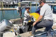  ?? PETER KROUSE / CLEVELAND.COM ?? Employees of LimnoTech prepare to have a smart buoy taken into Lake Erie and placed near a Cleveland Water intake near Euclid.