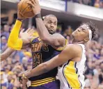  ?? DARRON CUMMINGS/ASSOCIATED PRESS ?? Cleveland’s LeBron James, left, grabs a rebound from Indiana’s Myles Turner during Sunday’s game.