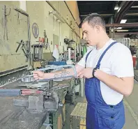  ??  ?? Der Auszubilde­nde Timo Schütz repariert Maschinent­eile in der Werkstatt des Betonwerks.
