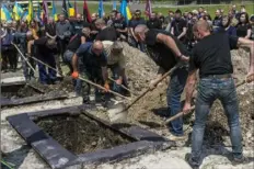  ?? Brendan Hoffman/The New York Times ?? Gravedigge­rs bury Bohdan Didukh and Oleh Didukh in a joint funeral on Monday at Lychakiv Cemetery in Lviv, Ukraine. The men shared a last name but never knew each other.