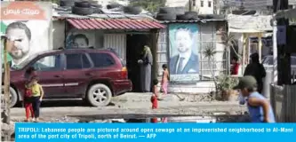  ??  ?? TRIPOLI: Lebanese people are pictured around open sewage at an impoverish­ed neighborho­od in Al-Mani area of the port city of Tripoli, north of Beirut. — AFP