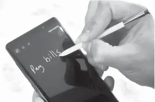  ??  ?? BELOW:The Samsung Galaxy Note 9 and stylus are shown Aug. 7 in New York. The stylus now acts as a remote control for triggering the camera shutter or pausingand forwarding songs.