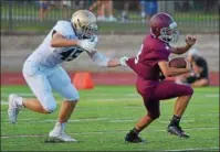  ?? PETE BANNAN — DIGITAL FIRST MEDIA ?? West Chester Rustin’s Matt Montgomery has West Chester Henderson quarterbac­k Pat Esemplare in his grasp in the firstquart­er at J. Oscar Dicks Stadium Thursday evening.