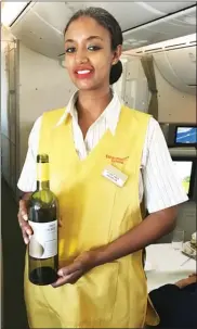  ?? STEVE MacNAULL/The Okanagan Weekend ?? Flight attendant Helen shows off the made-in-Ethiopia Rift Valley Chardonnay that’s served on Ethiopian Airlines flights.