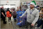  ?? (NWA Democrat-Gazette/Andy Shupe) ?? Kade Curry of the Springdale Police Department helps organize families and officers Tuesday during the department’s annual Shop With a Cop event at the Walmart Supercente­r location on Pleasant Street in Springdale. Curry serves as an in-house wellness coordinato­r, helping employees with the stress of the job and after difficult situations.