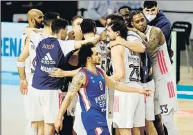  ?? FOTO: EFE ?? Shane Larkin se retira mientras los jugadores del Madrid se abrazan al final del choque