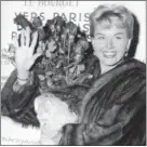  ?? ASSOCIATED PRESS FILE PHOTO ?? In an April 1955 photo, Doris Day holds a bouquet of roses at Le Bourget Airport in Paris, France, after flying in from London.