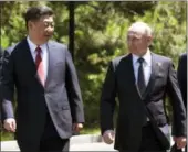  ?? THE ASSOCIATED PRESS ?? Russian President Vladimir Putin, right, and Chinese President Xi Jinping, left, walk prior to the opening ceremony of the Belt and Road Forum in Beijing on Sunday.