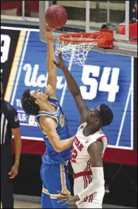  ?? Associated Press ?? PUSHING THROUGH UCLA guard Jules Bernard (1) shoots over Utah center Lahat Thioune (32) during the second half on Thursday in Salt Lake City. Bernard scored 19 points to help lead the Bruins to a 7661 victory over the Utes.