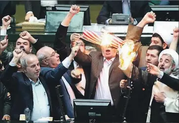  ?? Iranian parliament office ?? IN TEHRAN, shouts of “Death to America!” rang out in parliament as lawmakers set fire to a paper U.S. flag.