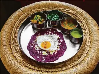  ??  ?? Houston Chronicle Beet uttapam — a fried egg-topped, beet-infused rice and lentil pancake served alongside peanut coconut salad, potato curry, sambhar and cilantro chutney — at Pondicheri