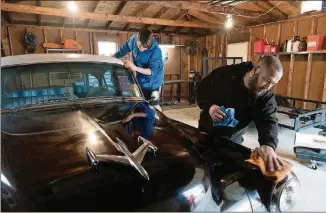  ?? PHOTO FOR THE WASHINGTON POST BY AMY POWELL ?? Ryan Hess and son Eli polish his 1953 Oldsmobile Rocket at home in Lawrencebu­rg, Indiana.