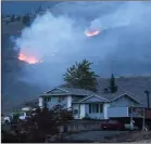  ?? CP PHOTO DARRYL DYCK ?? A wildfire burns last Sunday on a mountain in the distance behind a house that remains standing on the Ashcroft First Nation, near Ashcroft, B.C.