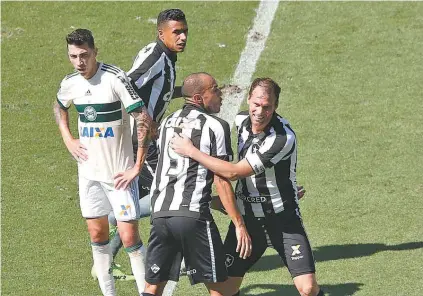  ??  ?? Carli festeja o seu gol com Roger, que marcou o primeiro do Botafogo no Nilton Santos: tropeço em casa