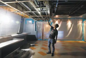  ?? Paul Chinn / The Chronicle 2019 ?? Biscuits and Blues owner Steven Suen in August inspects damage caused by flooding from Jack in the Box above. The nightclub closed in April but hopes to reopen.