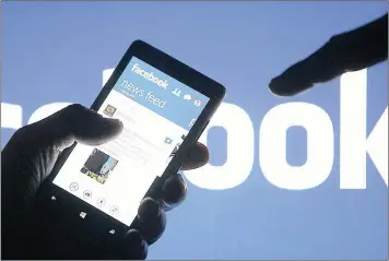  ?? PICTURE: REUTERS ?? HOOKED: A smartphone user shows the Facebook applicatio­n on his phone. Users are spending more time checking into social media and downloadin­g new apps to communicat­e in cyberspace.