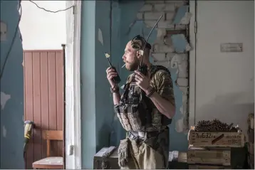  ?? OLEKSANDR RATUSHNIAK — THE ASSOCIATED PRESS ?? A Ukrainian soldier holds radios during heavy fighting Wednesday on the front line in Severodone­tsk, the Luhansk region, Ukraine.