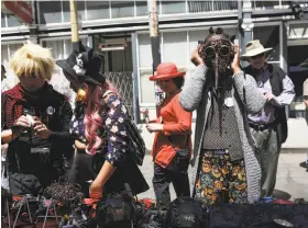  ??  ?? People try on masks at the How Weird festival in San Francisco’s South of Market neighborho­od, where costumes and nudity were both accepted.